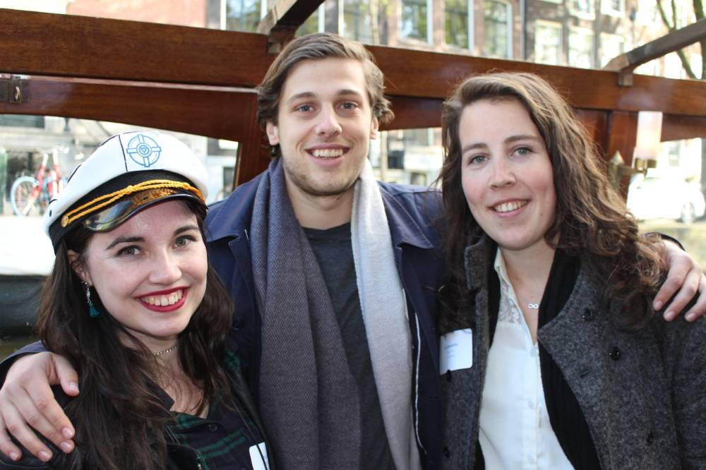 Two women, one in a sailors hat, and one man on a boat